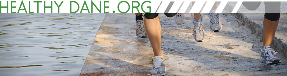 Group of runners on concrete next to a lake.